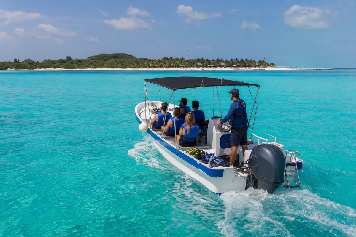 Small whale shark tour boat approaching Isla Mujeres with guests wearing life vests